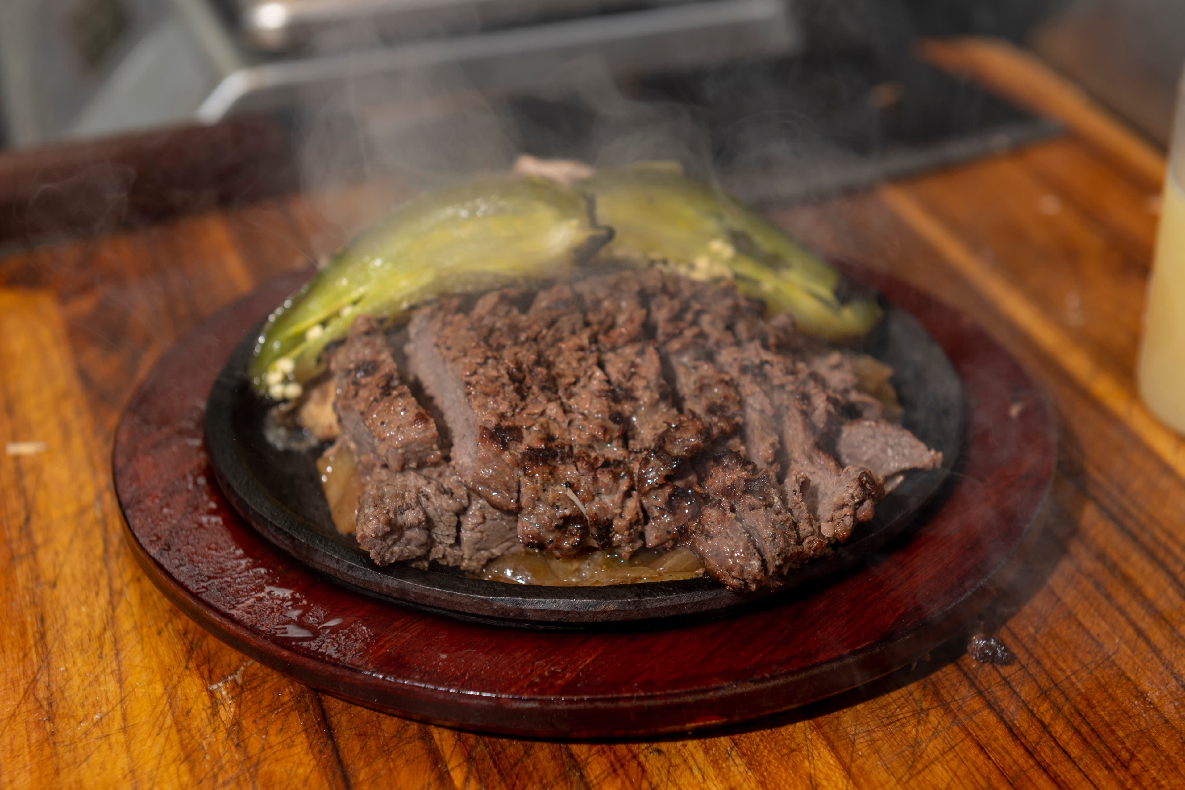 Beef fajita's sizzling on a cast iron plate